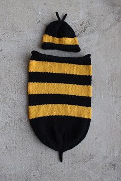 a black and yellow striped knitted hat laying on the ground