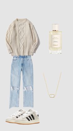 a sweater, jeans and sneakers are arranged on a white background with a bottle of perfume