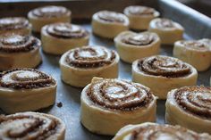 several cinnamon rolls on a baking sheet ready to be baked