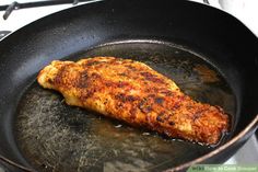 a piece of fish is cooking in a frying pan