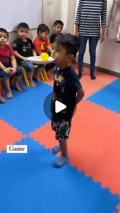 a little boy standing in front of a group of children