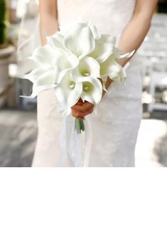 a bride holding a bouquet of white flowers