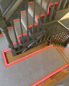 an image of a staircase with pink tape on the treads and handrails