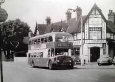 an old double decker bus driving down the street