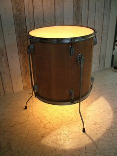 a close up of a drum on a floor with a light coming from it's side