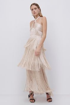 The Baldwin Draped Fringe Maxi Dress in Champagne. Flowing tiers of fringe transform a classic column dress into a symphony of motion. Contoured draping at the bust is complemented by a wrap halter neckline. Fringe Midi Dress, Classic Column, Shotgun Wedding, Holiday 2022, Satin Mini Skirt, Sequin Midi Dress, Column Dress, Fringe Dress