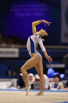 a woman is performing on the balance beam