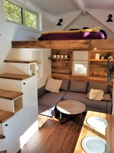 the interior of a tiny house with stairs leading up to the loft and living area