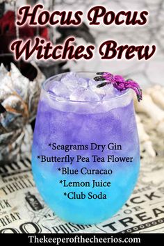 a purple and blue drink sitting on top of a newspaper with the words hoccus pocus witches brew