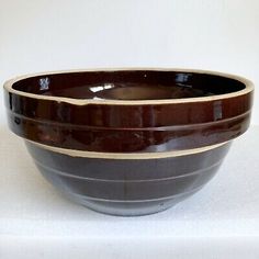 three brown and white bowls sitting on top of each other in front of a white wall