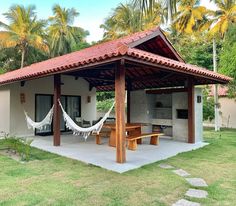 a small house with hammocks hanging from it's roof