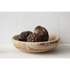 two mushrooms in a wooden bowl on a table