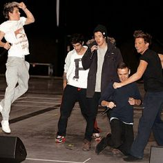 a group of young men standing next to each other on top of a parking lot