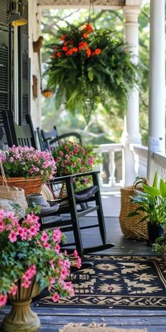 the front porch is decorated with potted plants and hanging baskets filled with pink flowers