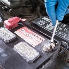 a person in blue gloves is working on an electronic device that has been placed under the hood of a car