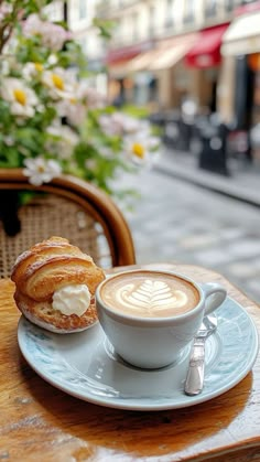 a cup of cappuccino on a saucer next to a pastry