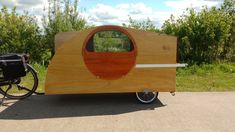 a small wooden trailer parked next to a bicycle