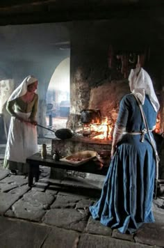 two women standing in front of an open fire