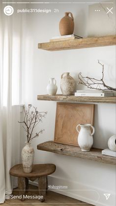 two shelves with vases and other items on them in a room that has white walls