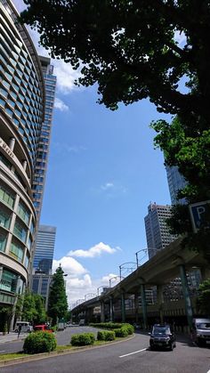 cars are driving down the street in front of tall buildings