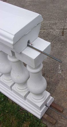 a white box sitting on top of a wooden post in the grass next to a sidewalk