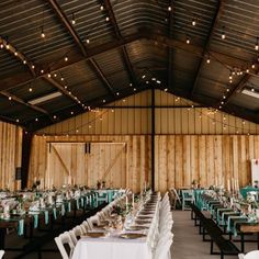 the inside of a barn with tables and chairs set up for an outdoor wedding reception