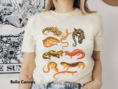 Matching tote bag now available: https://www.etsy.com/listing/1402912861/salamanders-canvas-tote-bag-cottagecore Comfort Colors Tee: https://www.etsy.com/listing/1392177610/all-salamanders-comfort-colors Sweatshirt: https://www.etsy.com/listing/1392161742/all-salamanders-crewneck-sweatshirts Kids Tees: https://www.etsy.com/listing/1392208494/all-salamanders-kids-tee-for-amphibian Nothing but salamander vibes in our new tees and sweatshirts! Soft, cozy, and amphibian-chic.  This listing is for Bella Canvas tees: 100% ringspun cotton and heathers colors are cotton/poly blend. Super soft, perfect for every day. Lots of colors, but please reach out if you need a different one!  We print our graphics on the shirt, not vinyl or iron-on!  Sizes - Adult Unisex Small - 3X (reach out for a custom fi Cute Salamander, 2016 Tumblr Outfits, Animal Gifts, Salamanders, Watercolor Cute, Kids Tees, Comfort Colors Sweatshirt, Kinds Of Clothes, Bella Canvas Tees