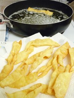 some fried food is being cooked in a frying pan on the stove top next to a skillet