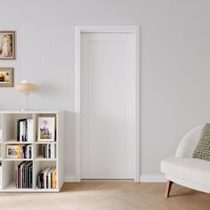 a living room with a white bookcase and pictures hanging on the wall above it