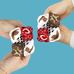 two hands holding small pieces of paper with different designs on them, one is red and the other is white