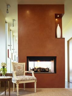 a living room filled with furniture and a fire place next to a wall mounted fireplace