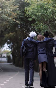 two people walking down the street with their arms around each other and one person wearing a suit