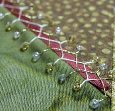 closeup of bead work on fabric with green and red material in the background