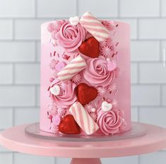 a pink cake decorated with hearts and flowers