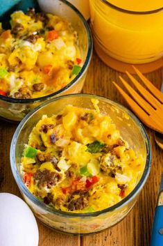 two glass bowls filled with food on top of a wooden table next to eggs and utensils