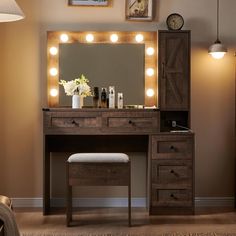 a vanity with lights on it and a stool in front of the mirror that is lit up