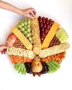 a turkey shaped platter filled with cheese, crackers, grapes, and nuts