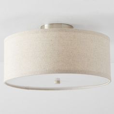 a white ceiling light with a beige shade