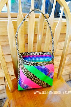 a colorful purse sitting on top of a wooden chair