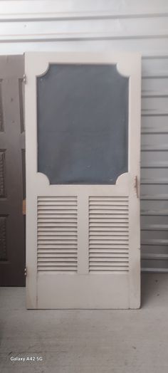 an old white door with shutters in front of a garage