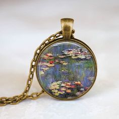 Handmade art pendant necklace featuring Water Lilies by Claude Monet. You can choose your finish between antique bronze, antique silver,  gunmetal or antique copper.**********************************************************************This beautiful pendant is handcrafted by me... using a high quality art print image and is protected by a beautiful crystal clear domed glass cabochon which enhances the image for a truly stunning effect!The glass cabochon measures approximately 1 inch in diameter. Artsy Gold Round Pendant Necklace, Antique Gold Copper Necklace For Gift, Antique Gold Nickel-free Necklace Gift, Antique Gold Nickel-free Necklace For Gift, Artistic Bronze Jewelry With Artistic Design, Bronze Jewelry With Artistic Design, Bronze Antique Finish Round Pendant Necklace, Bronze Round Pendant Necklace With Antique Finish, Artistic Bronze Jewelry Gift