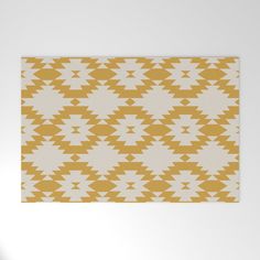 a yellow and white rug with triangles on it