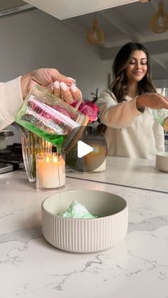 a woman is pouring something into a blender