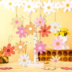 some paper flowers are in a vase on a table