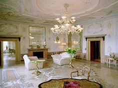 a fancy living room with chandelier and white furniture