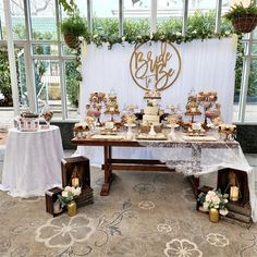 a table covered in lots of desserts next to a sign that says bride and groom