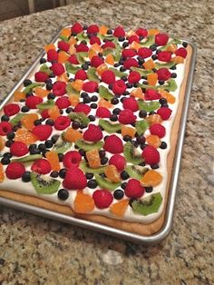 a cake with fruit on it sitting on top of a counter