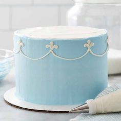 a frosted blue cake sitting on top of a table