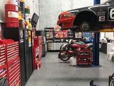 a red motorcycle is on the rack in a garage