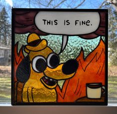 a stained glass window with a dog saying this is fine next to a cup of coffee